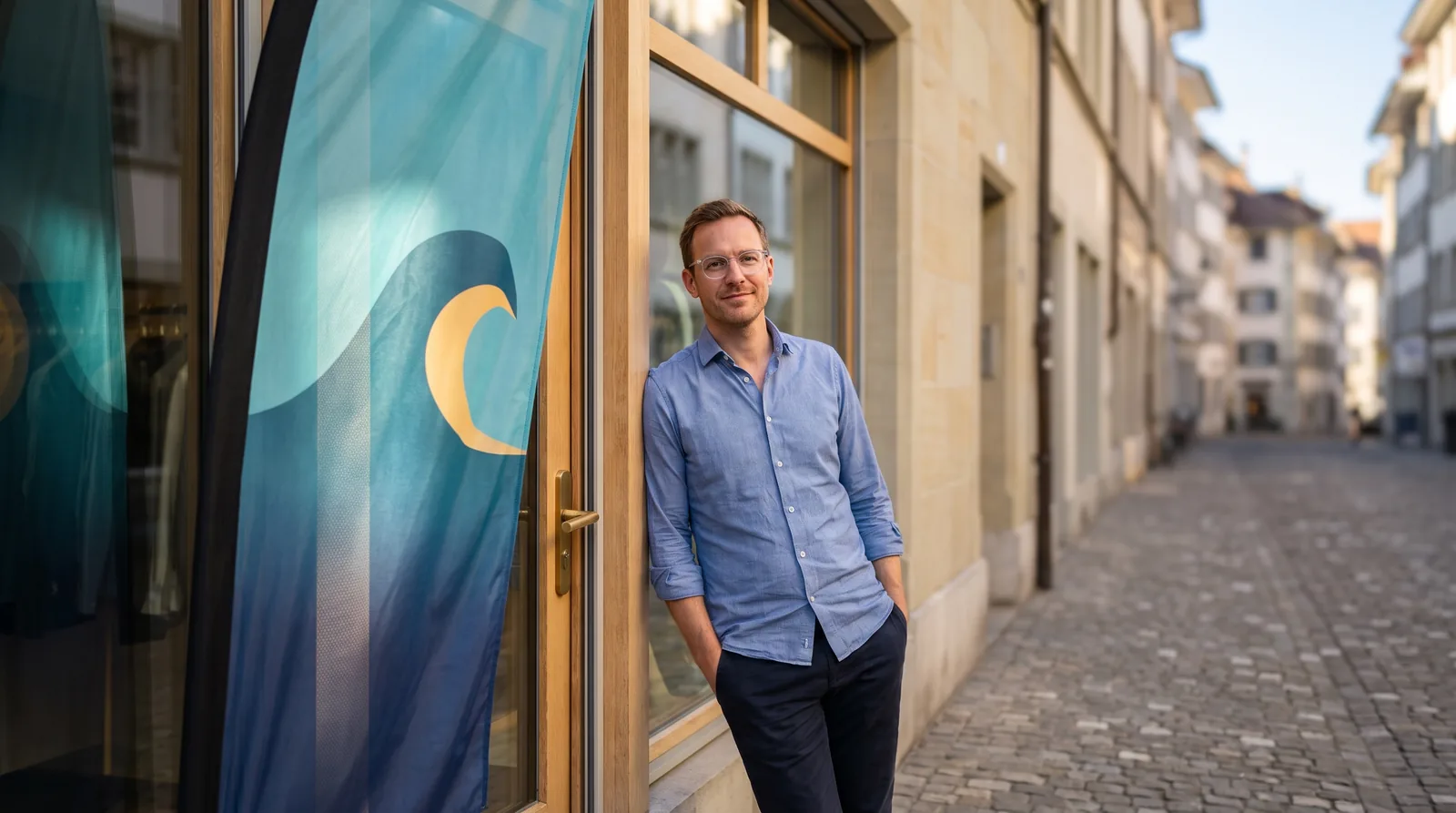 Bannerfahne mit Wellen-Motiv am Ladeneingang in einer Schweizer Altstadt – Werbefahne von Chill & Easy